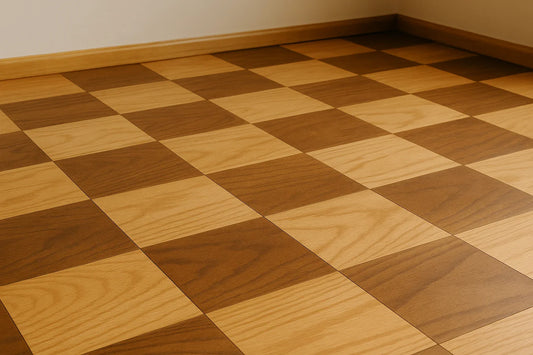 Checkerboard stained wood floor in warm oak tones, with sunlight highlighting natural grain and geometric pattern.