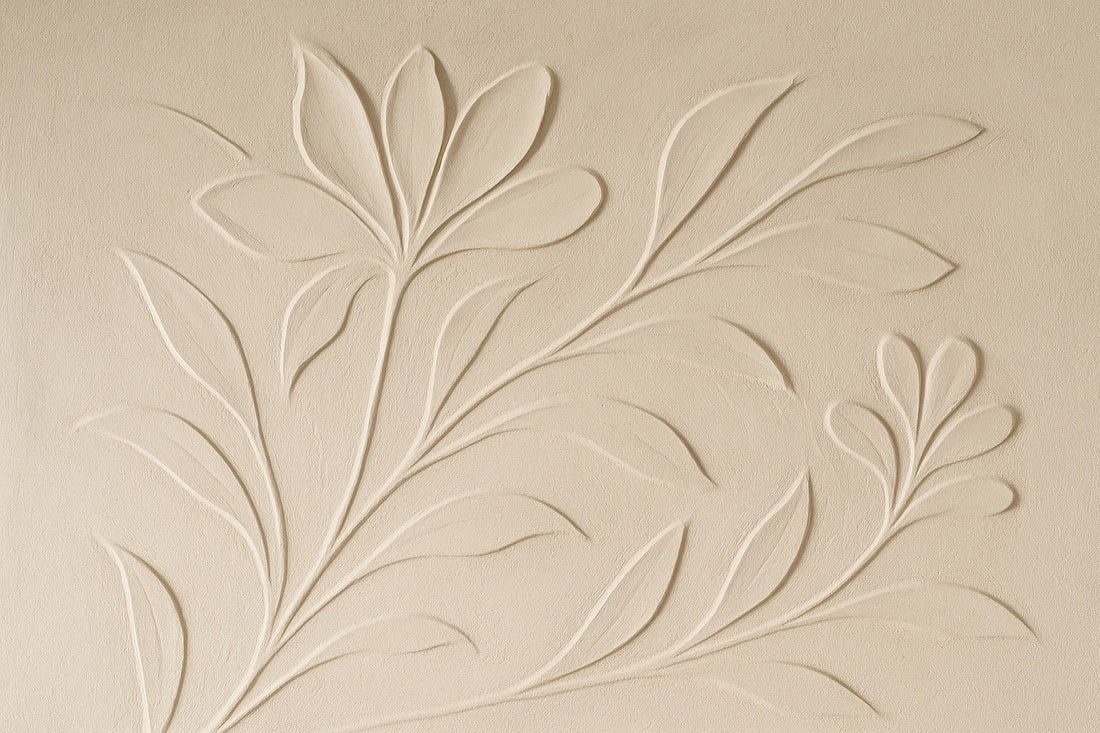Textured plaster relief wall with sculpted botanical motifs and soft shadows in a calm, neutral-toned interior.