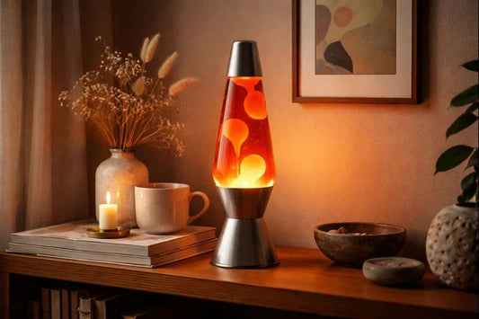 Glowing lava lamp on a wooden shelf with dried flowers, a candle, books, and a ceramic cup in warm ambient light